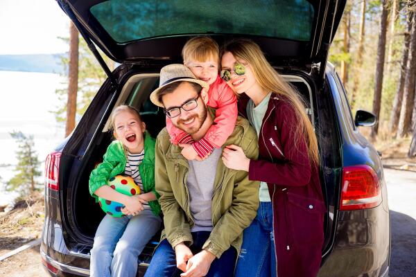 a family sitting in the open trunk of a car